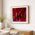 Abstract painting in a gold frame on a wall above a wooden console table with decorative items.